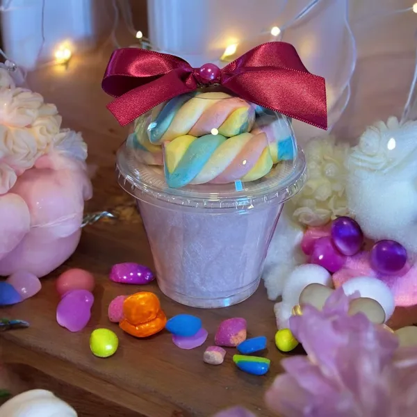 Copo de algodão-doce lilás com marshmallows coloridos e laço rosa escuro