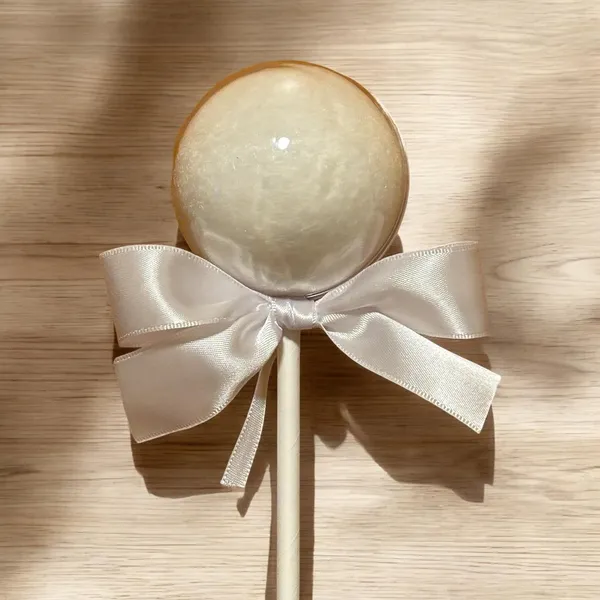 Pirulito de algodão-doce branco com laço de cetim branco